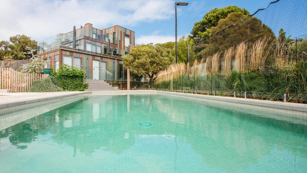 a swimming pool with blue water in front of a building at Back Beach in Portsea