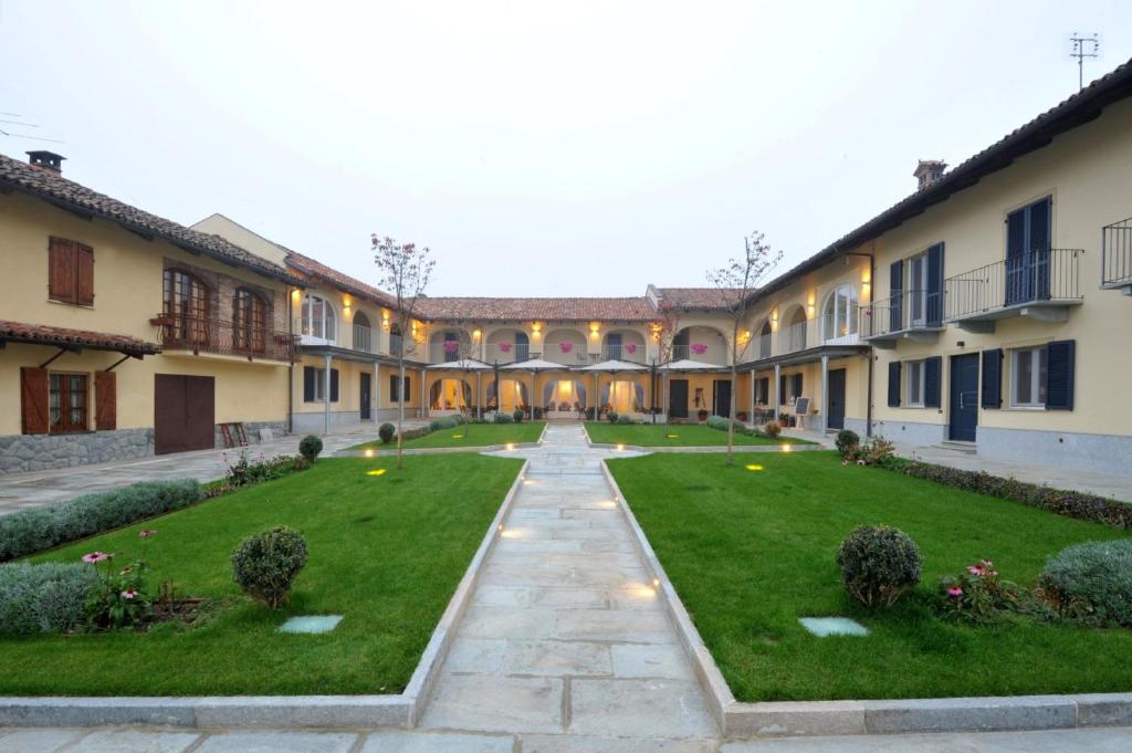 une cour vide d'un bâtiment avec pelouse dans l'établissement Agriturismo Cascina Varìe, à Castagnito