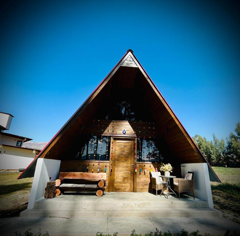 a building with a wooden door and a table at La Encantada Cabañas in Cajamarca