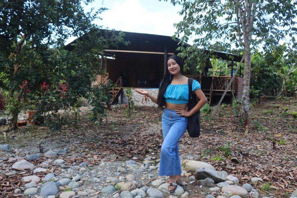 a woman standing on a pile of rocks at Cabaña Princesa de Agua in Tena