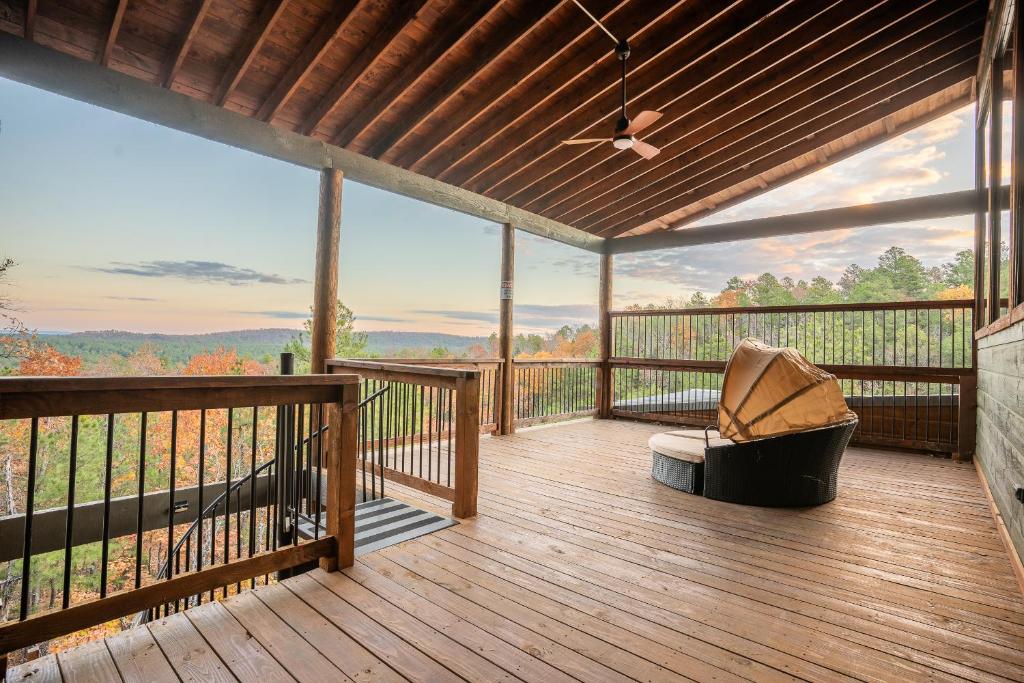 a screened in porch with a chair on a deck at Brand New Luxury Mountain Retreat Awaits You! in Broken Bow