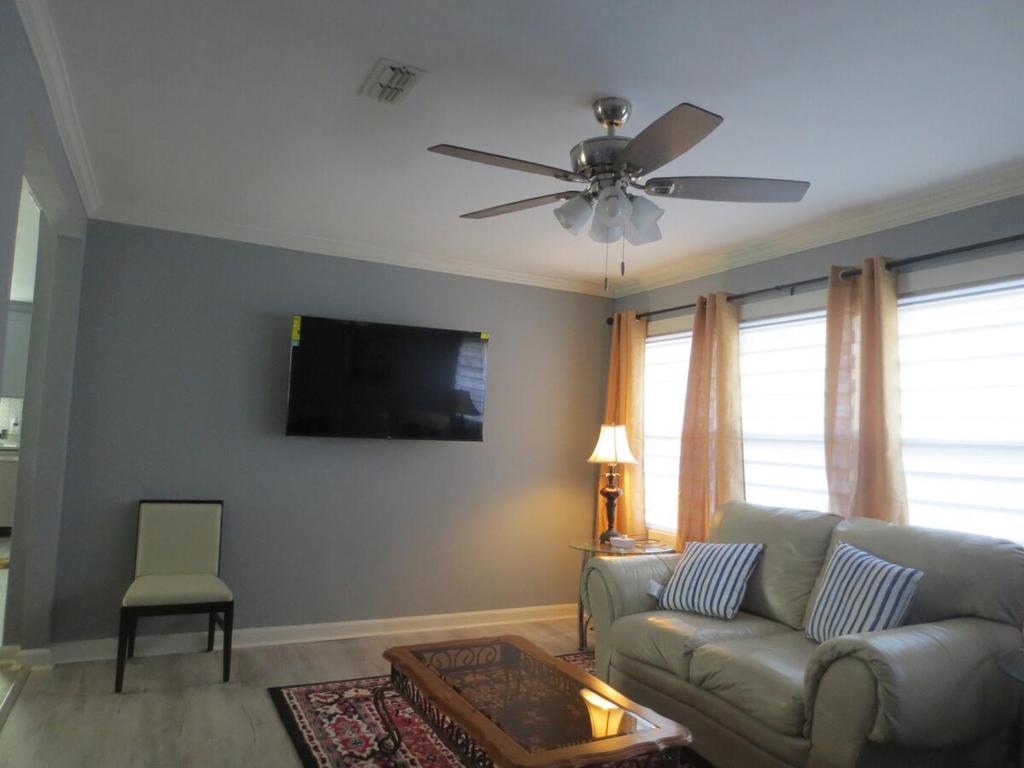 een woonkamer met een bank en een plafondventilator bij 3 Bed 2 Bath renovated house in West Rome in Rome