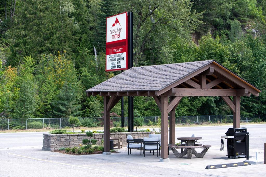 a pavilion with a picnic table and a gas station at Swiss Chalet Motel in Revelstoke