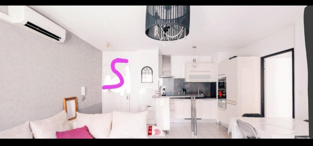 un salon avec un canapé blanc et une cuisine dans l'établissement Appart cosy Marseille, à Marseille