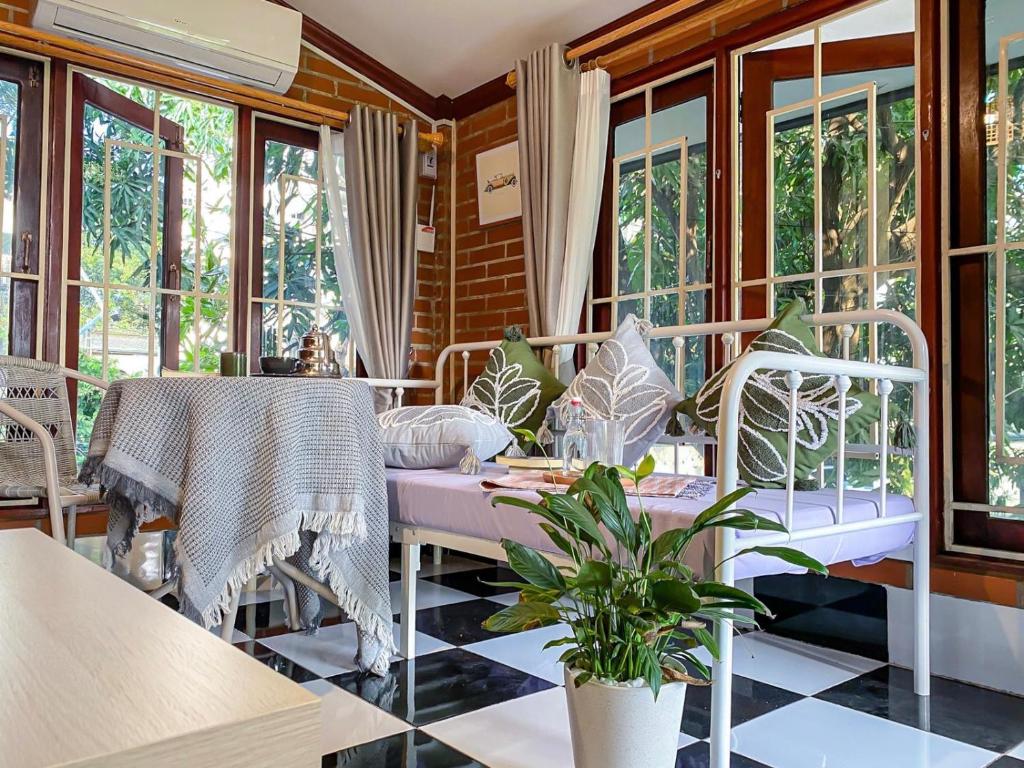 a room with a table and chairs and windows at The Giftown Vientiane, Watchan in Vientiane