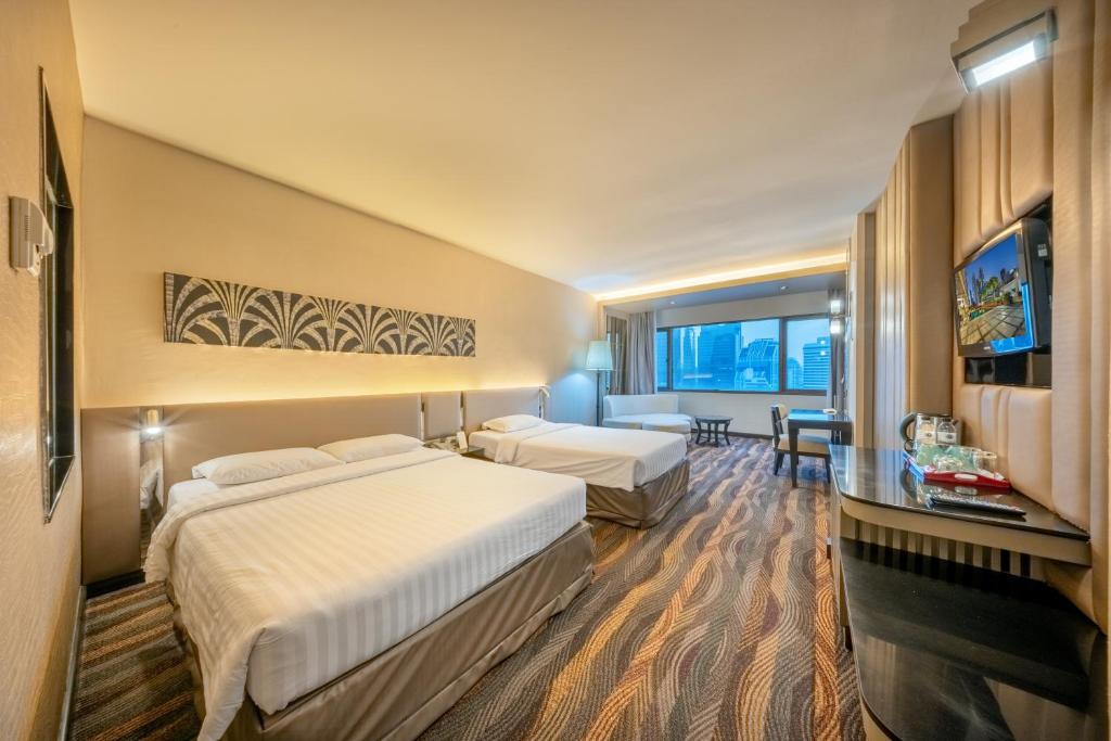 a hotel room with two beds and a television at Royal Benja Hotel - Big Room Family-Friendly in Bangkok