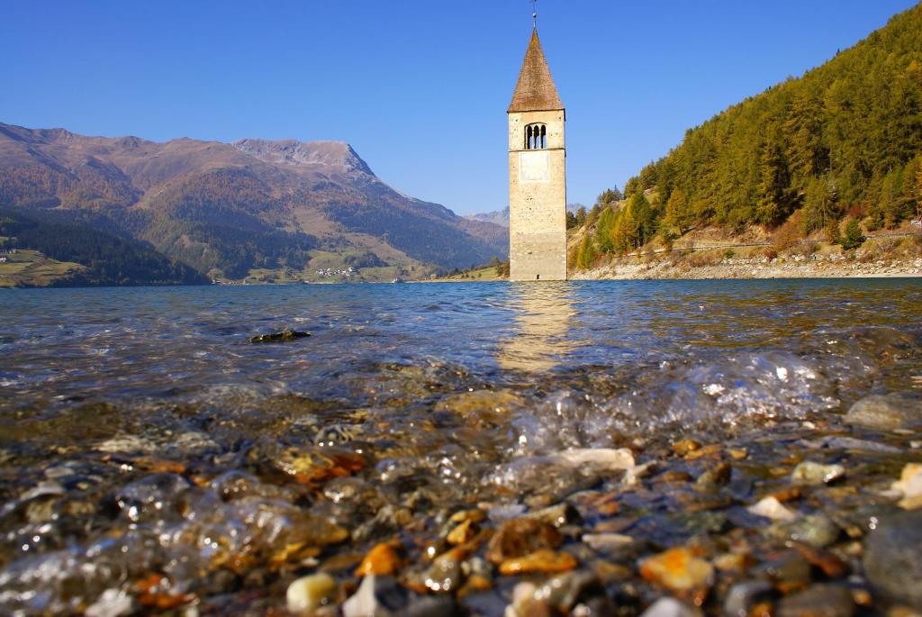 een vuurtoren in het midden van een waterlichaam bij Apart Bergzeit in Nauders