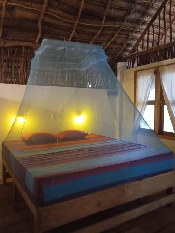 un letto con un baldacchino di plastica in una stanza di The Alpha Monkey hotel & Tree house a Tangalle