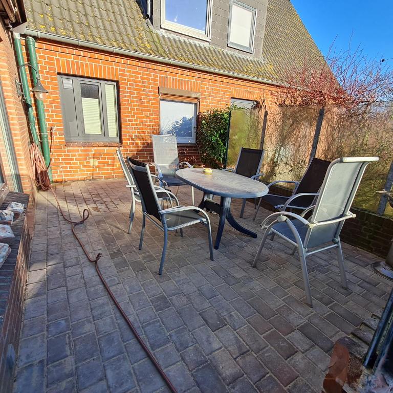 a patio with a table and chairs and a building at Wohnung Lemkenhafen in Fehmarn