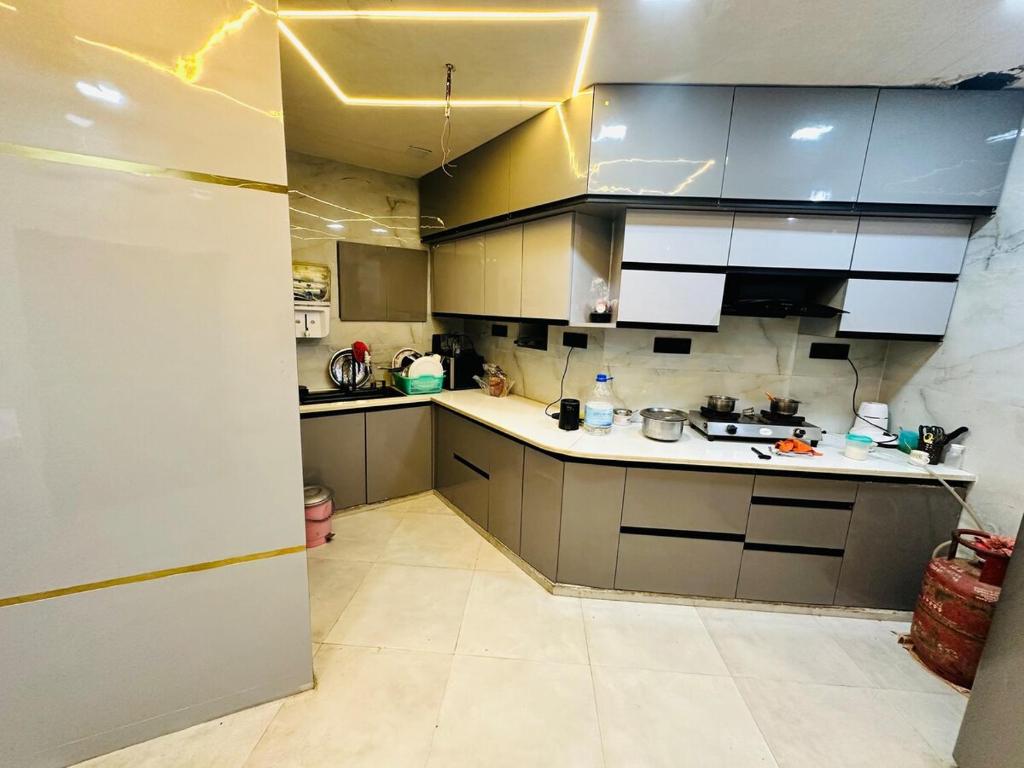 a kitchen with gray cabinets and white counter tops at Taj Castle Homestay sutable for 17 Peoples in Agra