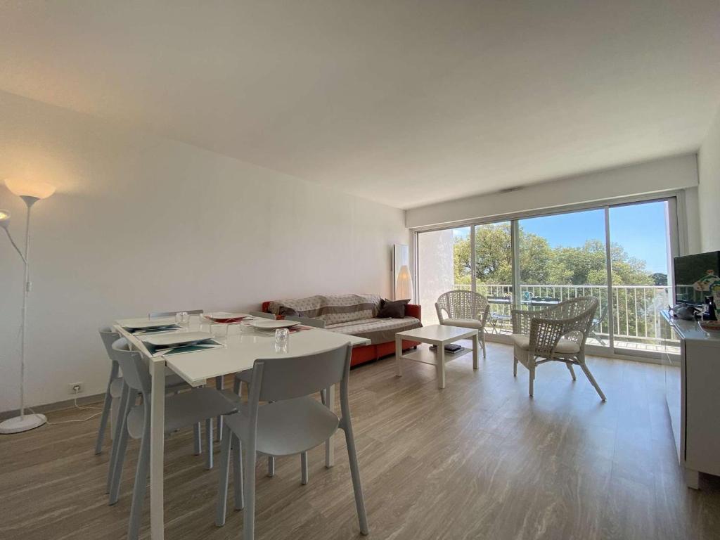 un salon avec une table, des chaises et un canapé dans l'établissement Appartement 4 pièces/6 couchages proche plage - LE POULIGUEN - FR-1-245-210, au Pouliguen