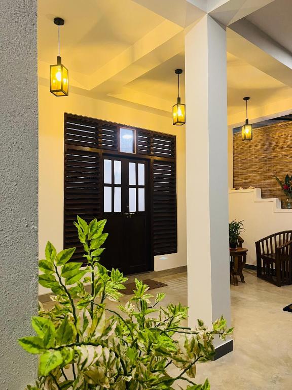 a lobby with a black door with black shutters at Sunset Villa in Unawatuna