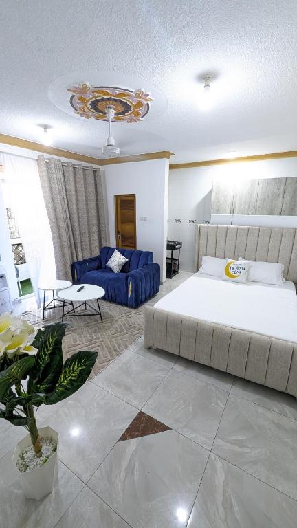 モンバサにあるElegant Studio in Bamburi Fisheriesの大きなベッドと青いソファのある寝室