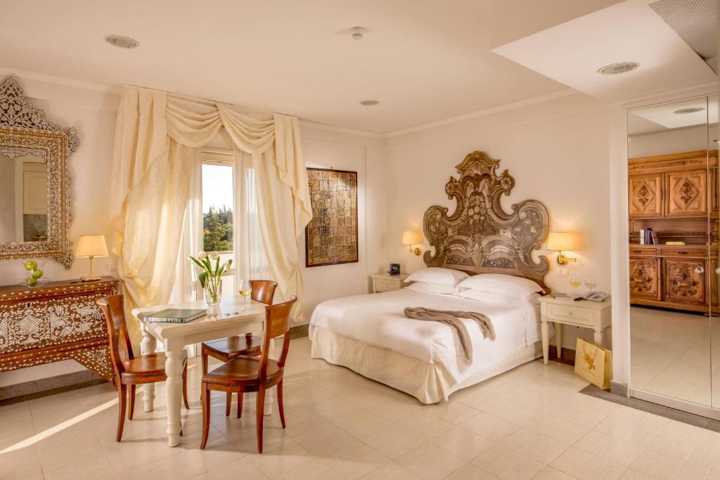 Arcom Palace في بوميتسيا: غرفة نوم بسرير كبير وطاولة وكراسي
