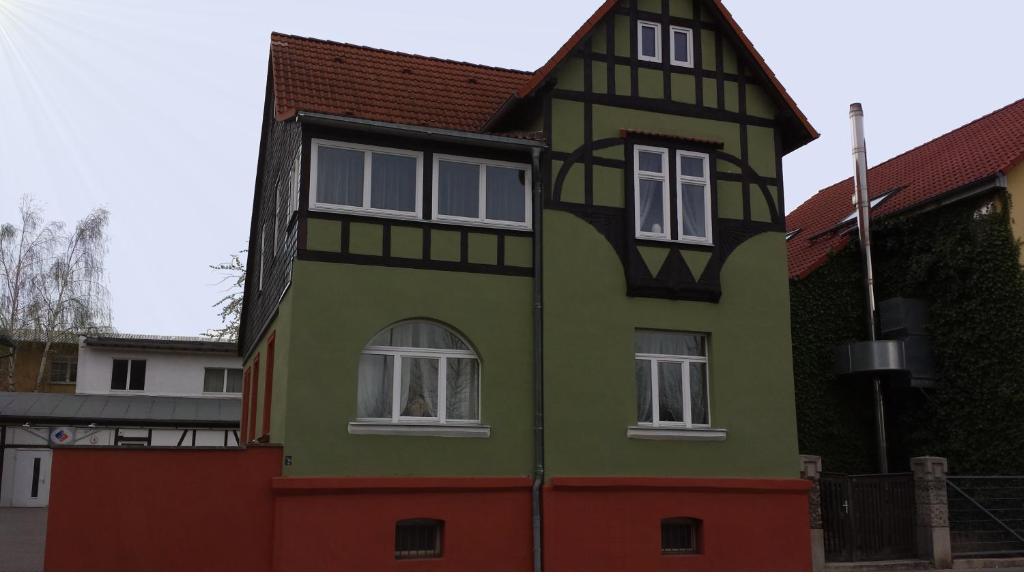ein grünes und orangefarbenes Haus mit weißen Fenstern in der Unterkunft Villa Anneliese in Weimar