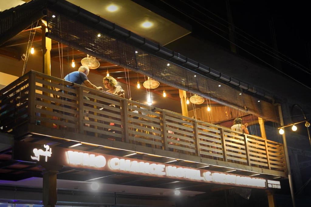 a group of people standing on the balcony of a restaurant at Who Chance Hotel and Restaurant in Habaraduwa