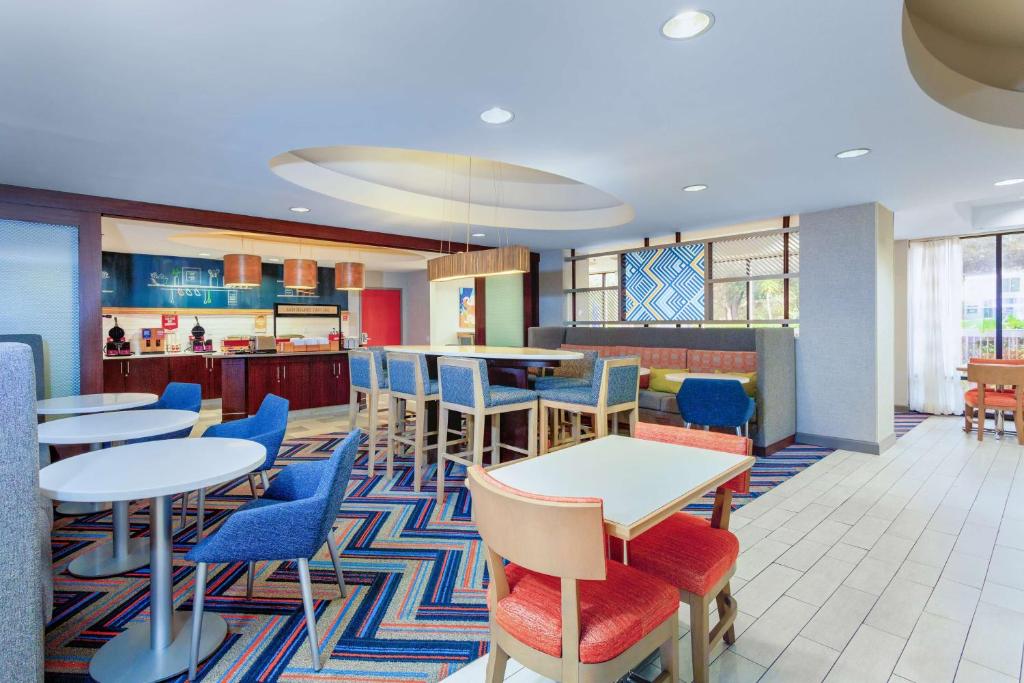 a restaurant with tables and chairs and a cafeteria at Hampton Inn Orlando-International Airport in Orlando