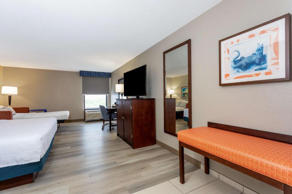 a hotel room with a bed and a mirror at Hampton Inn Orlando-International Airport in Orlando