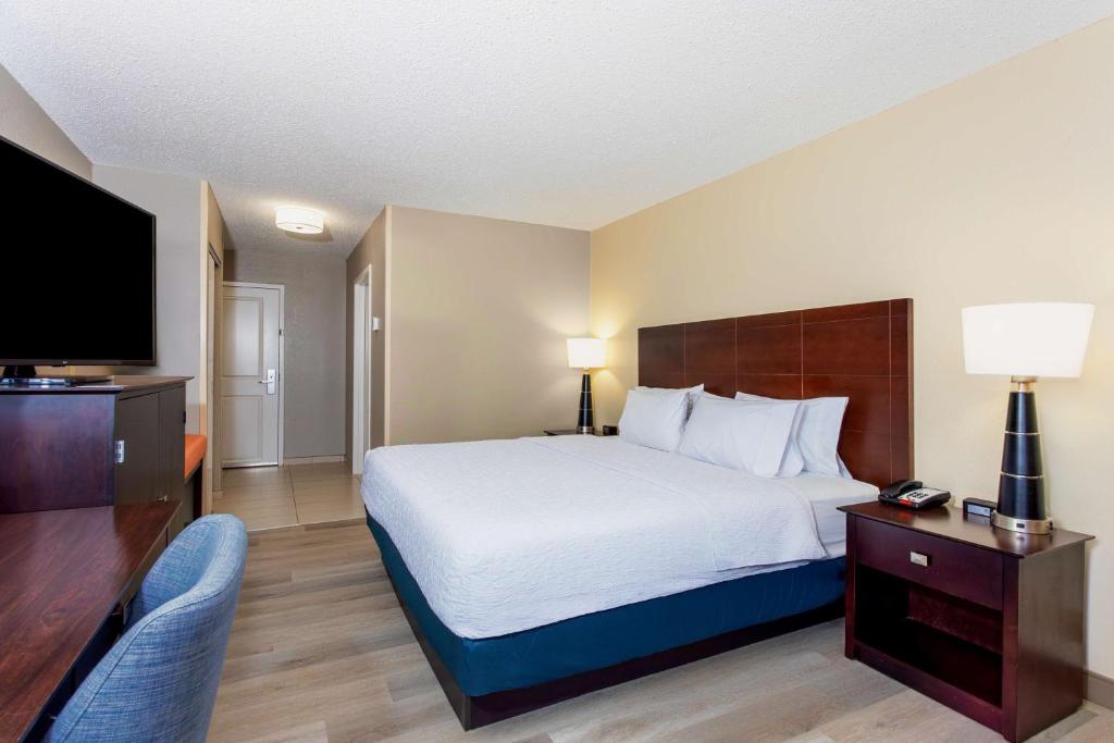 a hotel room with a bed and a flat screen tv at Hampton Inn Orlando-International Airport in Orlando
