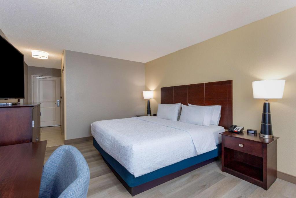 a hotel room with a bed and a television at Hampton Inn Orlando-International Airport in Orlando