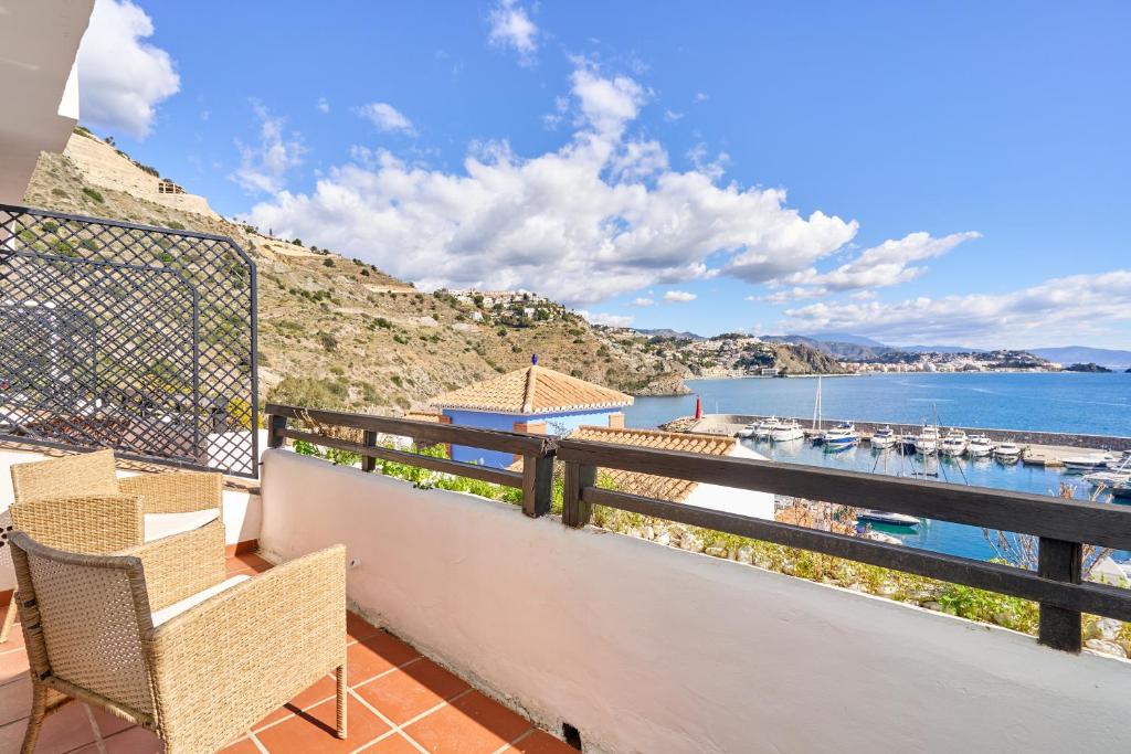 a balcony with chairs and a view of the water at Casa Maritima in La Herradura