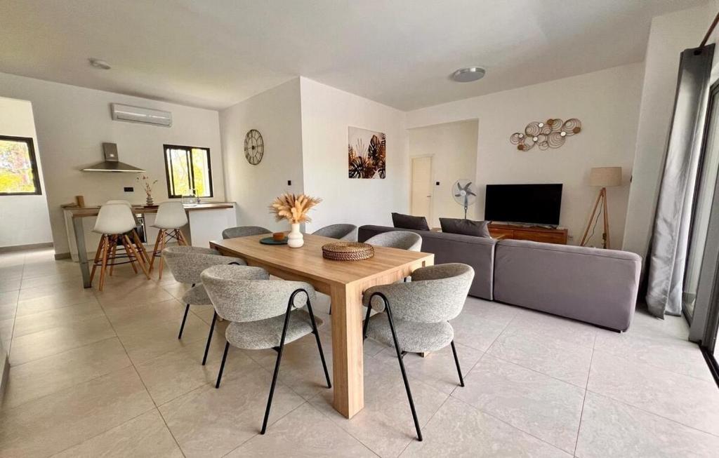 a living room with a wooden table and chairs at Coastal View 2 Apartments North in Grand Baie