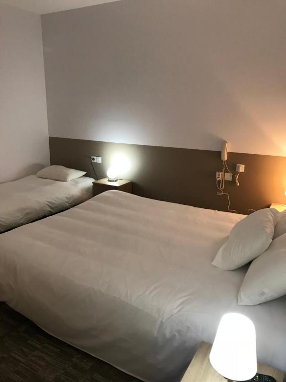 Postel nebo postele na pokoji v ubytování Hotel du Clocher
