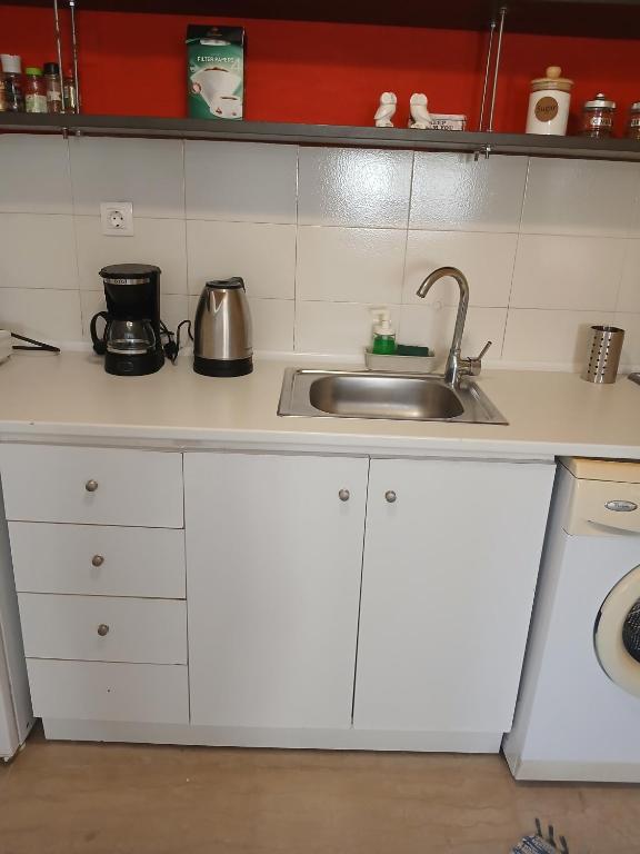 a kitchen with white cabinets and a sink at Athina in Thessaloniki