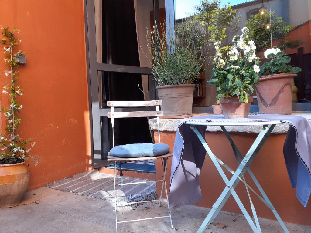 a chair sitting next to a table with potted plants at un oasis au coeur de la vieille ville, classé 4 étoiles in Montpellier