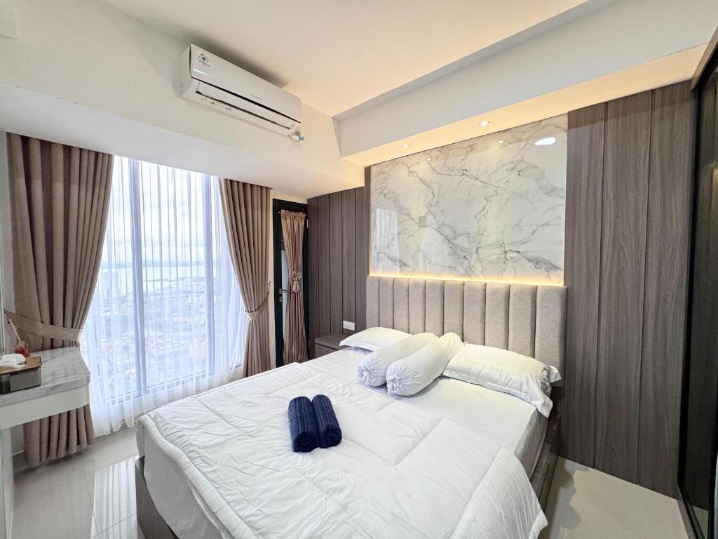 a bedroom with a bed with two blue pillows on it at Panoramic Seaview Studio High-Floor and Free WiFi in Batam Center