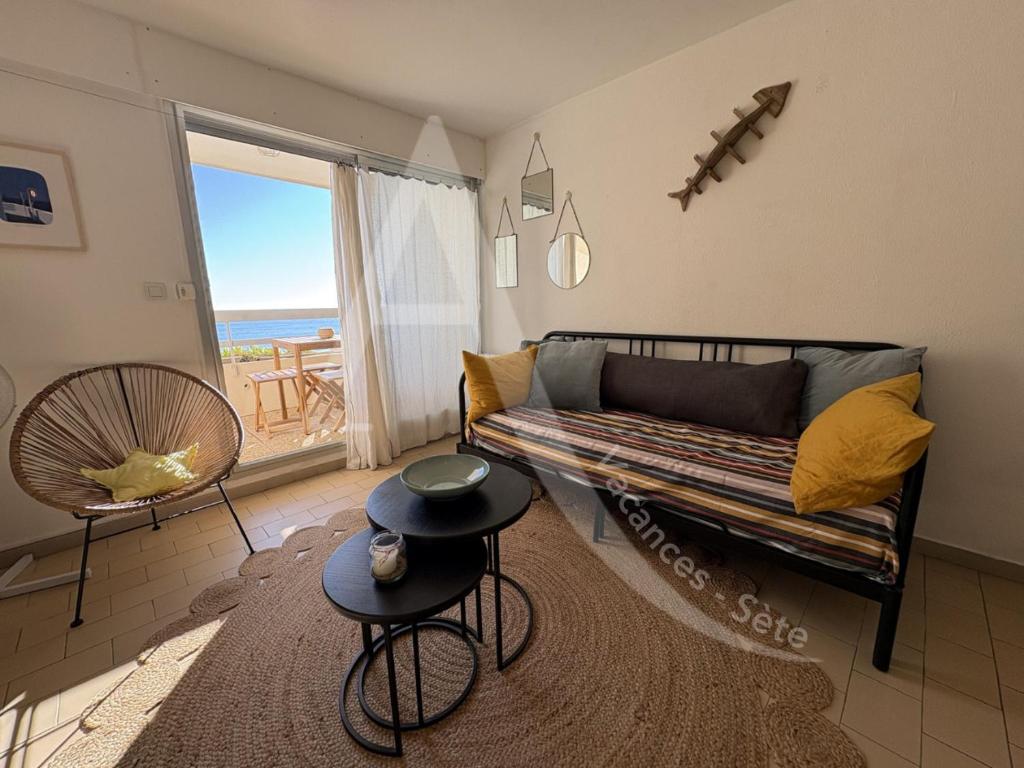 un salon avec un canapé et une vue sur l'océan dans l'établissement T3 moderne, vue mer et parking, à Sète