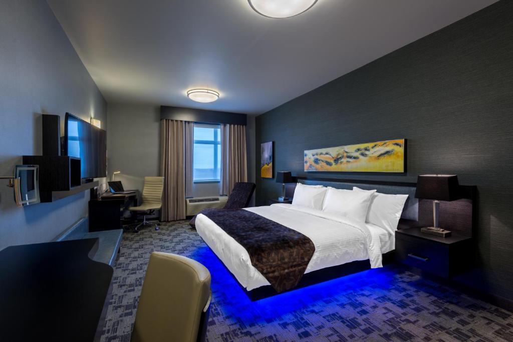 een hotelkamer met een groot bed en een bureau bij Applause Hotel Calgary Airport by CLIQUE in Calgary