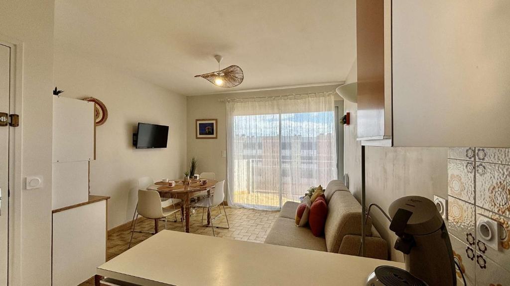 une cuisine et un salon avec un canapé et une table dans l'établissement Appartement 4 personnes - PORT LA NOUVELLE PN650-096, à Port-la-Nouvelle