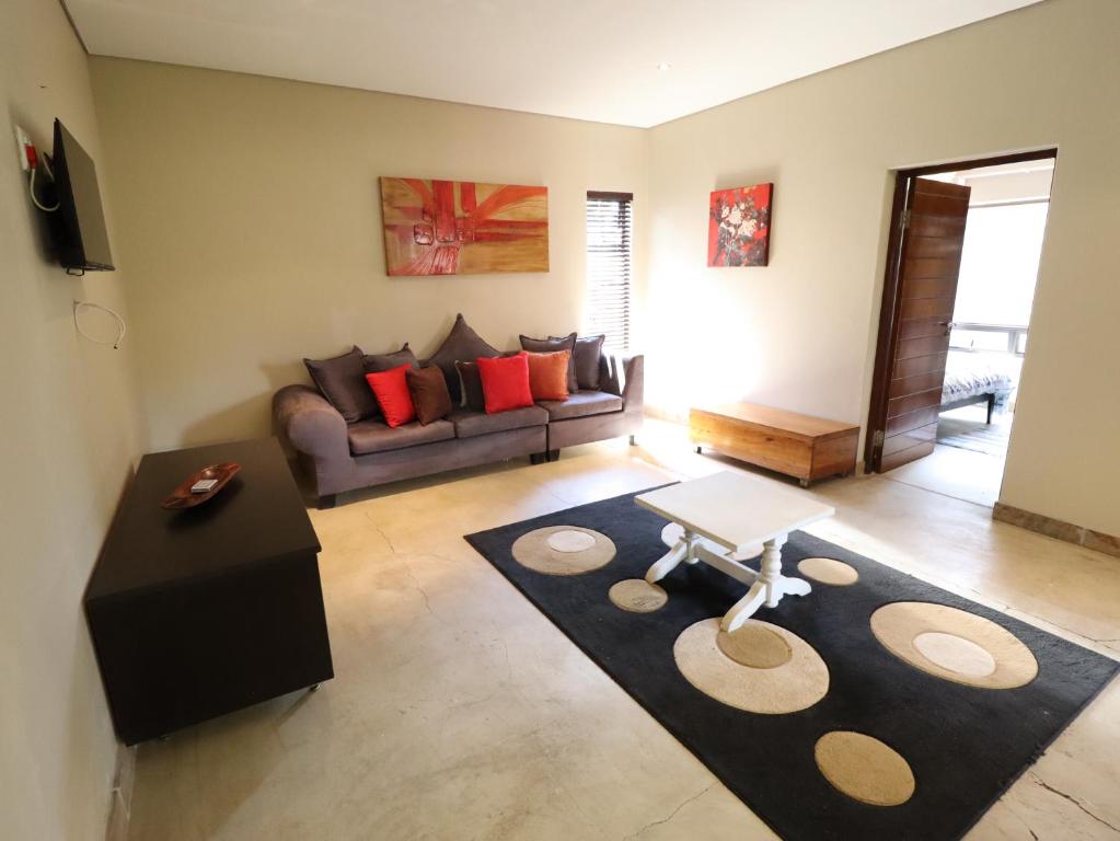 a living room with a couch and a table at Modern 1 Bedroom Apartment in Bloemfontein