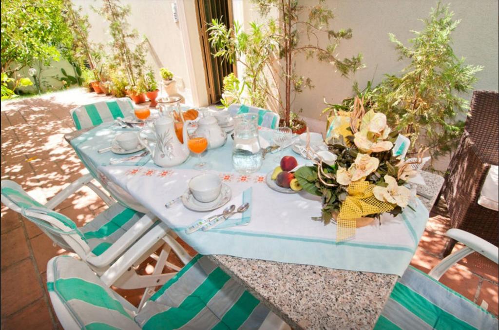 un tavolo con una tovaglia blu e fiori sopra di B&B Casa Rosino a Dolianova