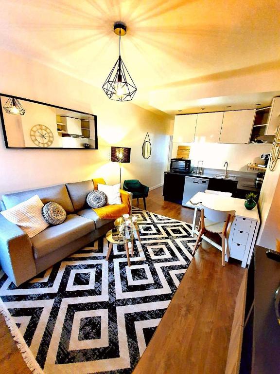 un salon avec un canapé et une cuisine dans l'établissement F2 Moderne Confort, Hyper Centre, à Enghien-les-Bains