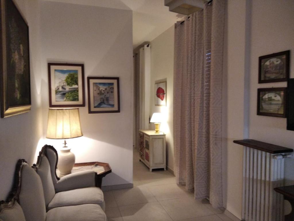 een woonkamer met een stoel en een lamp bij Casa Vacanza -Trani centro in Trani