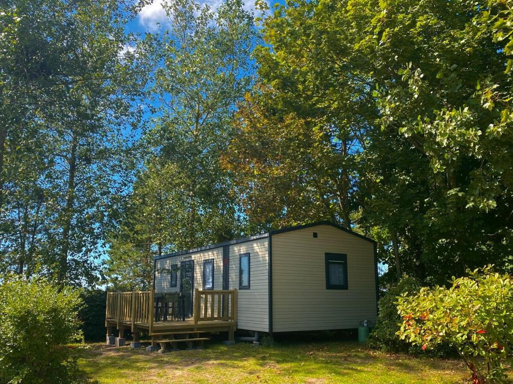 une petite maison avec un porche et une terrasse dans l'établissement Élégant mobil-home, à Le Touquet Airport