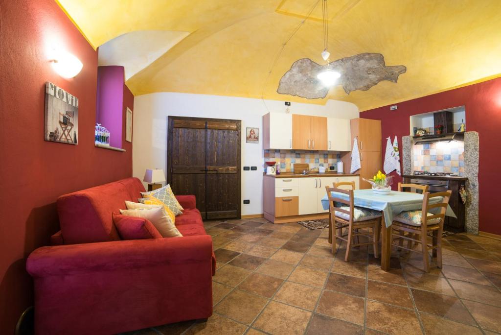 アローナにあるCasa Corte Alla Roccaのリビングルーム(赤いソファ、テーブル付)