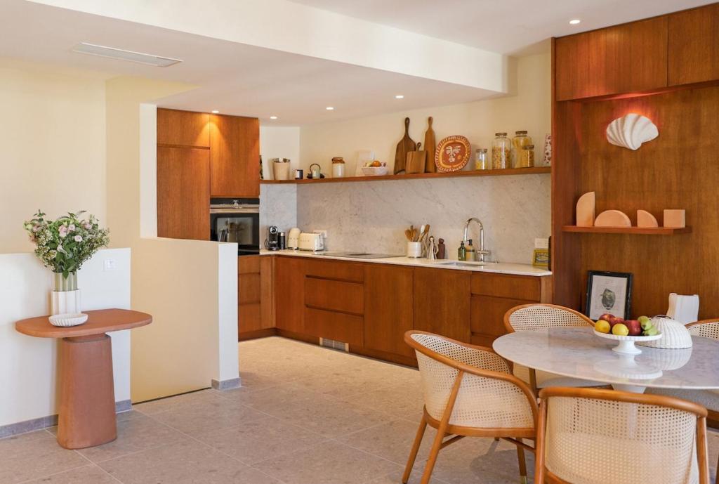 une cuisine avec une table, des chaises et un réfrigérateur dans l'établissement Luxury duplex in Saint Tropez, à Saint-Tropez