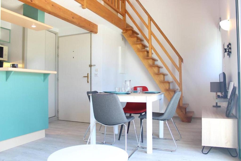 une table et des chaises dans une pièce avec un escalier dans l'établissement Appt 2 pièces mezza LA ROCHELLE - LR020-317, à La Rochelle