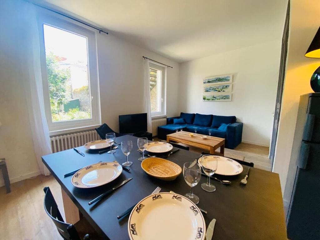 - un salon doté d'une table avec des assiettes et des verres à vin dans l'établissement Casa du Mail, à Angers