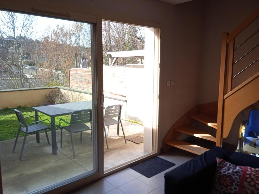 d'une chambre avec une table, des chaises et une porte coulissante en verre. dans l'établissement Chez Malya, maison au calme, proche du lac, à Charavines