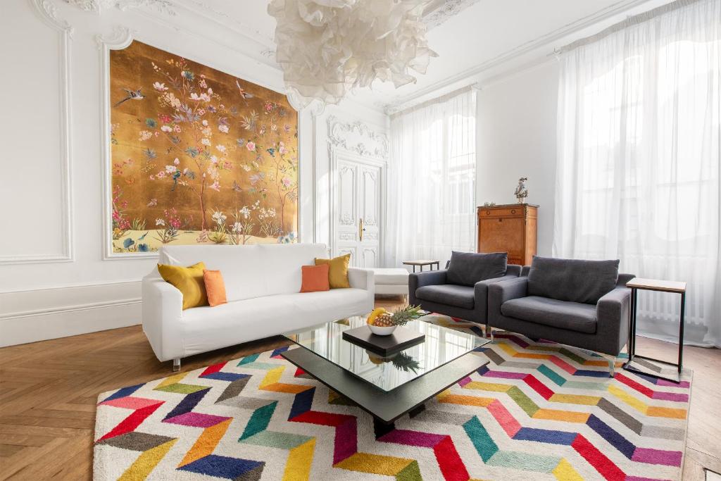 - un salon avec un canapé blanc et un tapis coloré dans l'établissement le RAMOND, à Carcassonne