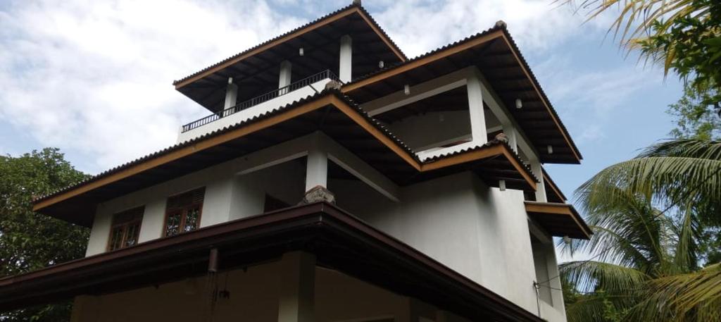 a building with a balcony on top of it at Ruvini Villa in Hikkaduwa