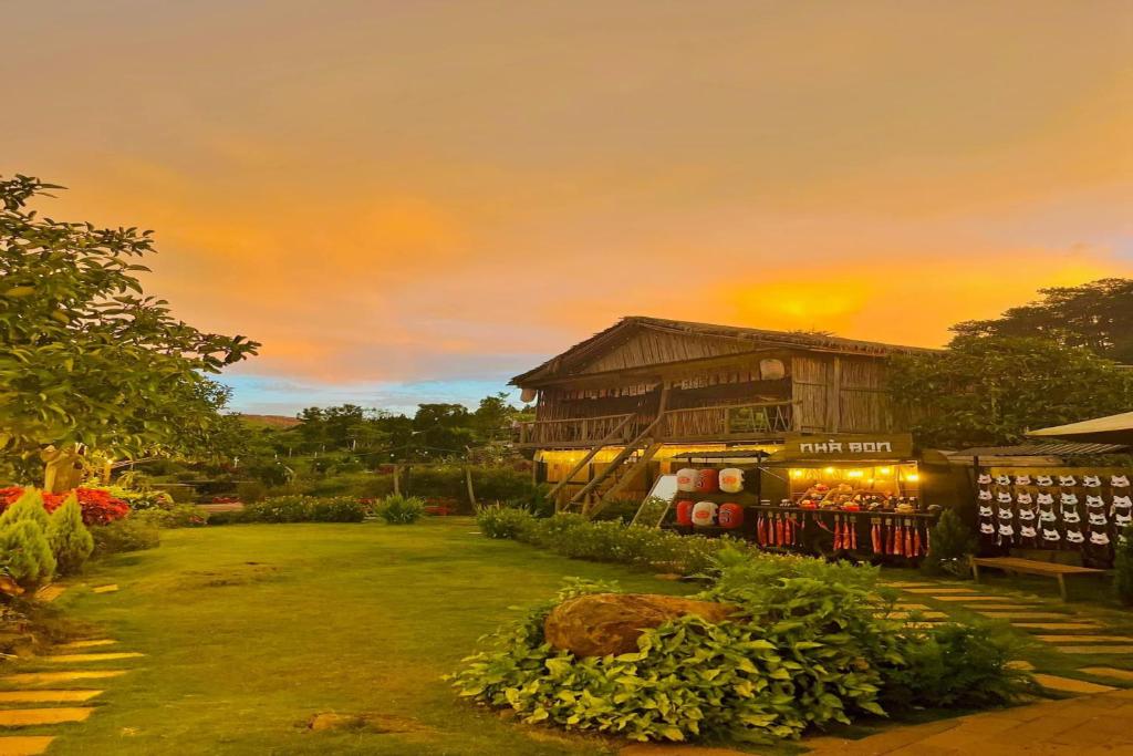 a house with a garden with a sunset in the background at BonBon Villa & Coffee in Bảo Lâm