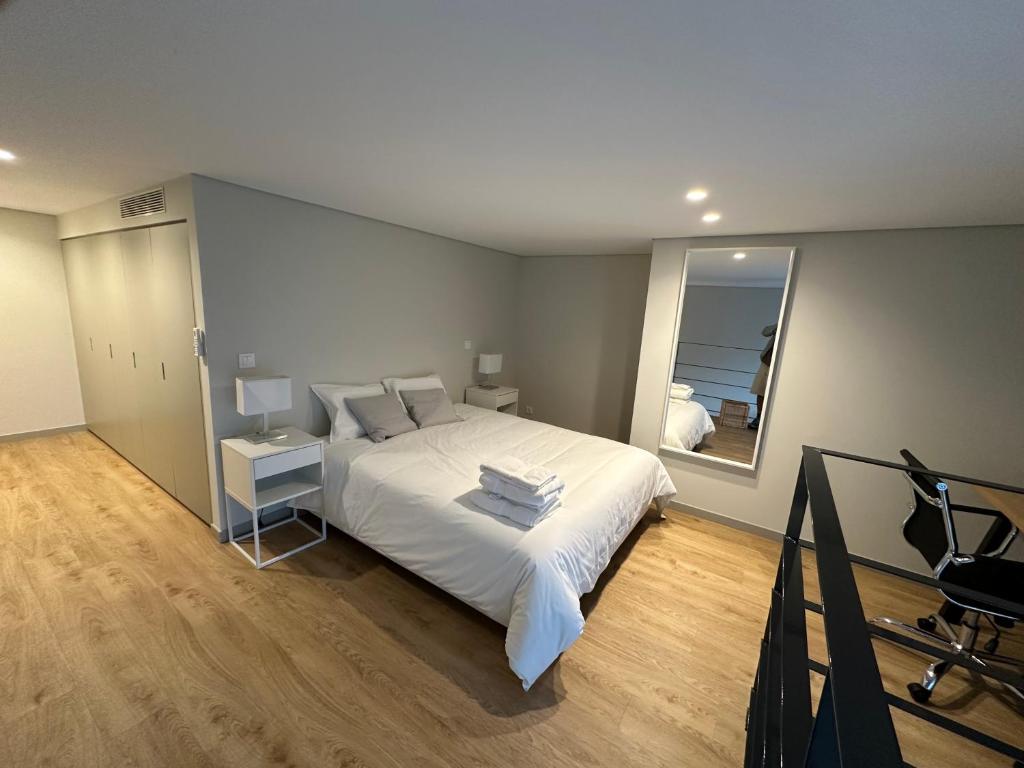 a bedroom with a large white bed and a mirror at NEW Douro 901 Mezzanini with parking in Vila Nova de Gaia