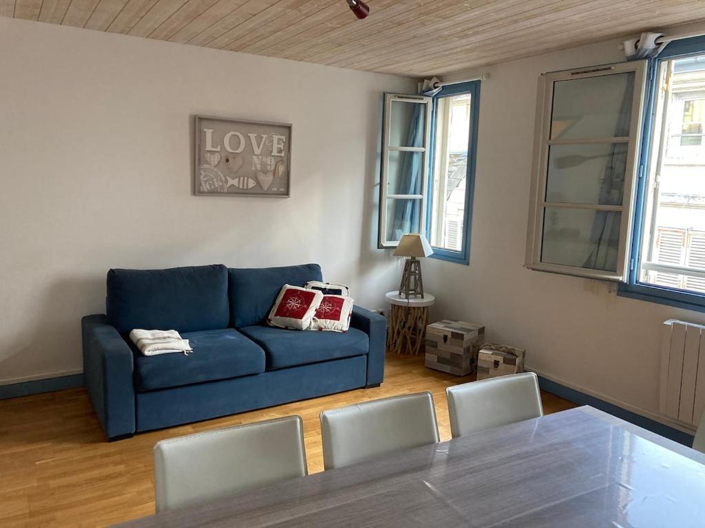 un salon avec un canapé bleu et des chaises dans l'établissement Cour du Temple - vieux Port 6 pers - 3 étoiles, à La Rochelle