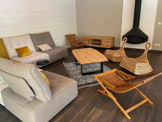 un salon avec un canapé, une table et des chaises dans l'établissement Villa OLYMPE & son T2, à Andernos-les-Bains