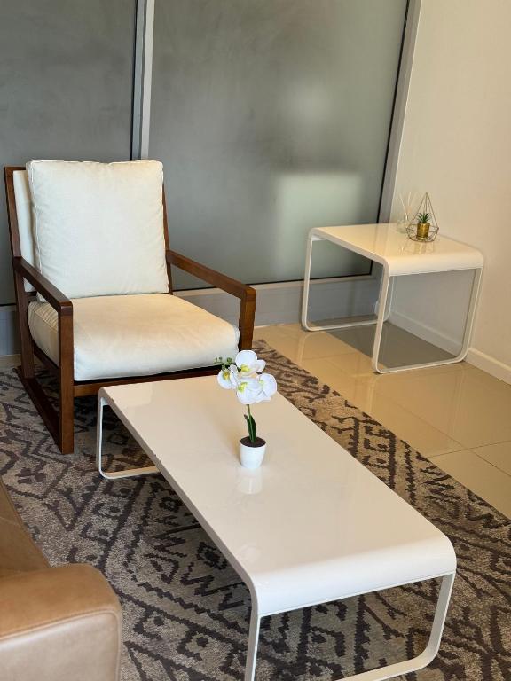 a living room with a chair and a coffee table at Cosy one bedroom apartment in Windhoek
